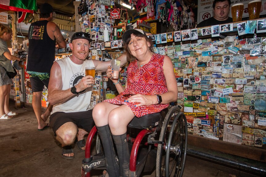 Man with woman in wheelchair in a remote outback pub.