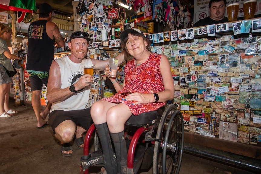 Man with woman in wheelchair in a remote outback pub.