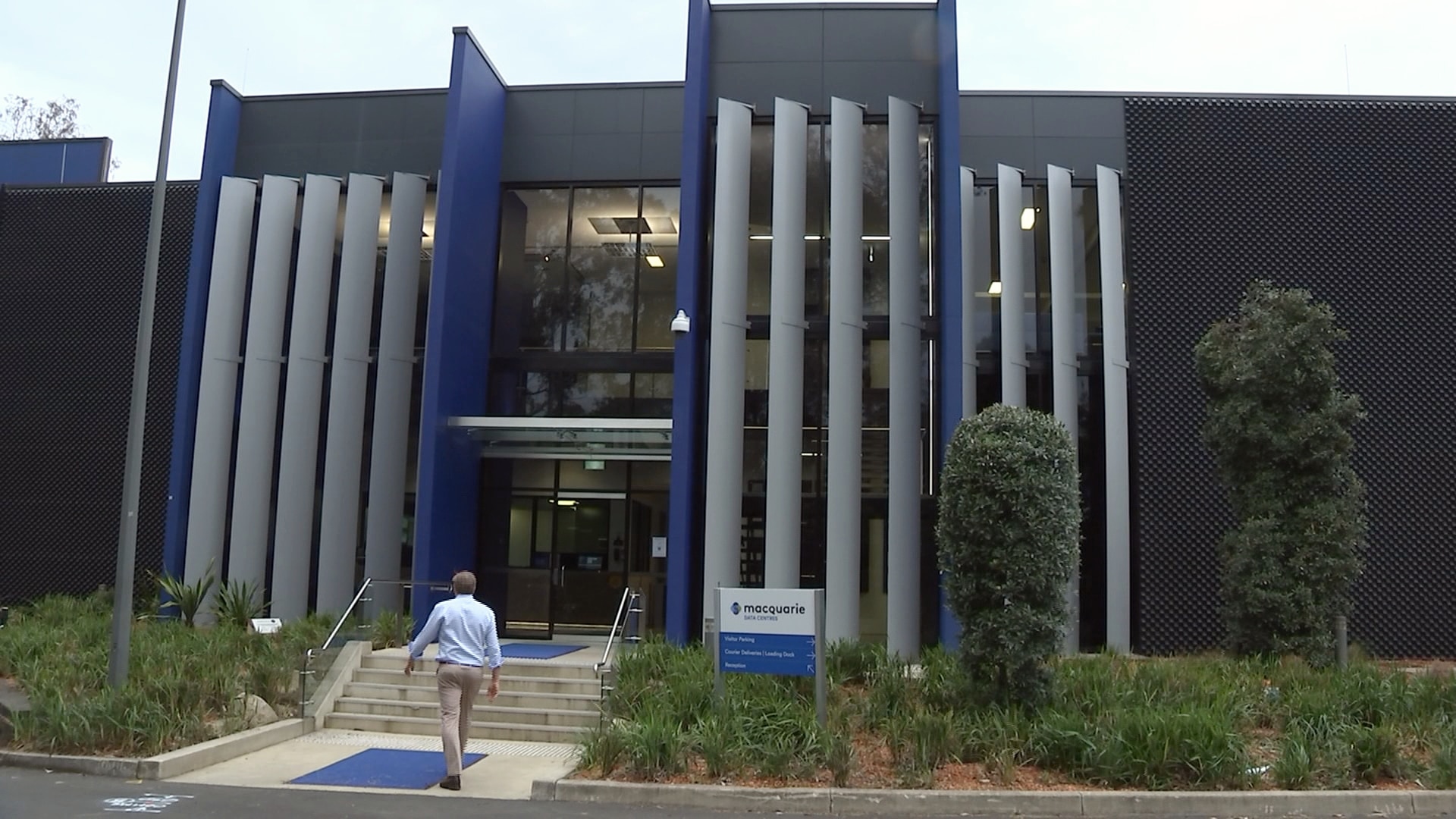 a man walks towrads the entrance of the macquarie park data centre at macquarie park