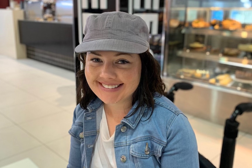 A lady smiling at the camera with a hat on