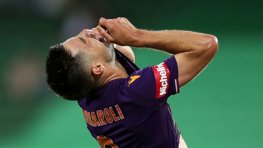 A head and shoulders shot of Perth Glory player Bruno Fornaroli looking up with his hands towards his head in despair.