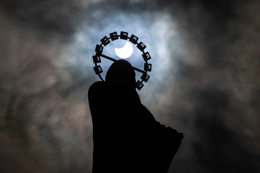 Our Lady, Star Of The Sea on Bull Wall in Dublin, is silhouetted against the sky during a partial solar eclipse
