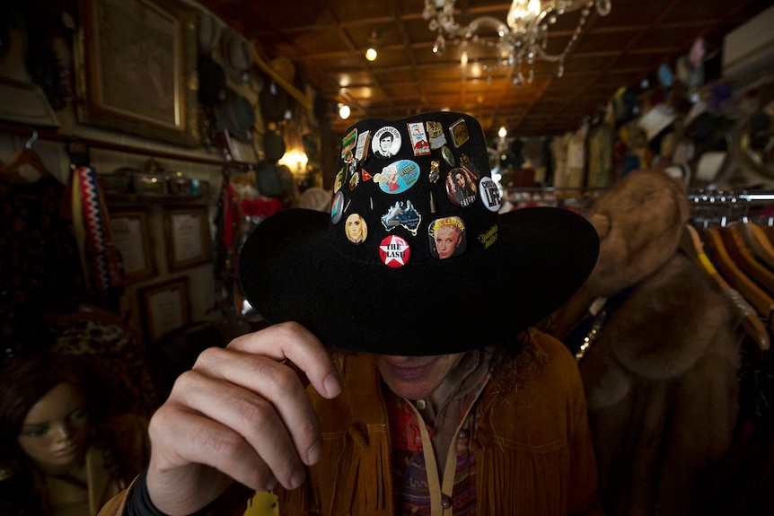 The badges on his hat embrace an eighties rock music theme.