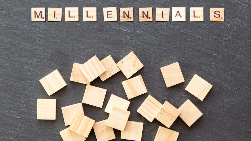 Scrabble pieces on slate block spelling 'millennials'.