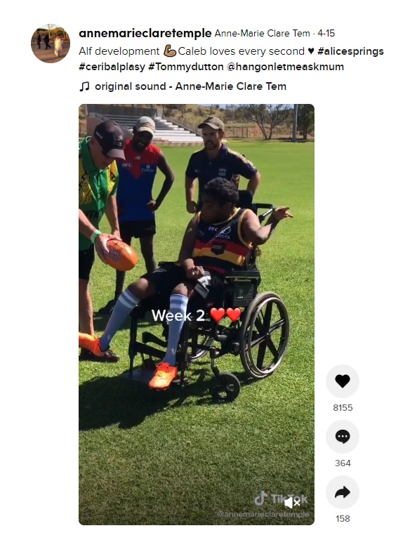 A screenshot of a TikTok video showing man in a wheelchair kicking a football.