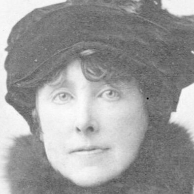 Black and white photo of Elizabeth Von Arnim wearing a hat and scarf