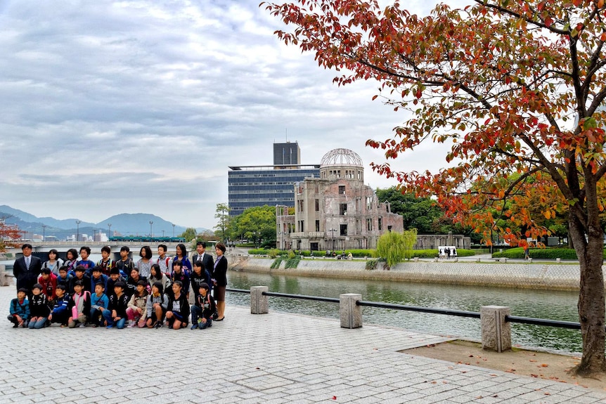 Tourists pose for a photo in front of The A-Bomb Dome in Hiroshima