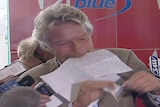 Richard Branson tears up a cheque during a press conference.