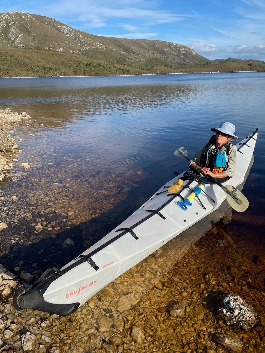 A woman in a kayak on a lake.