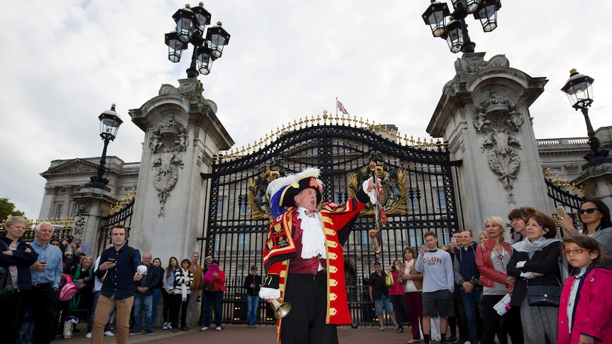 Crowds gather to watch town crier Tony Appleton proclaims the record breaking reign of Britain's Queen Elizabeth II outside Buckingham Palace