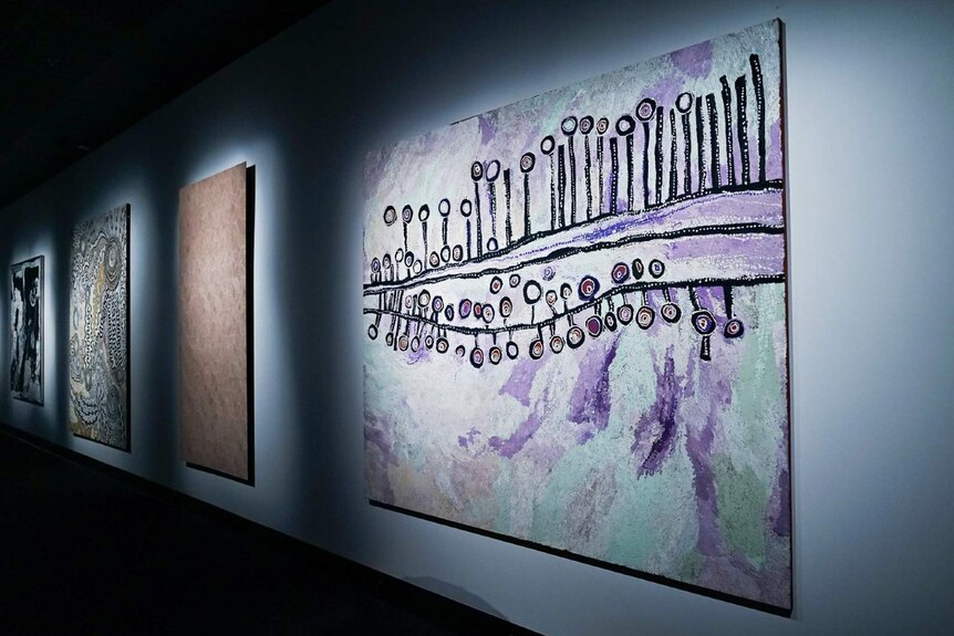 A photo of a purple, black and white painting hung on the walls of the Museum and Art Gallery of the NT.
