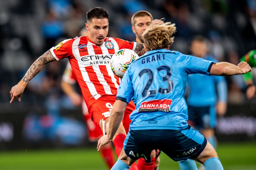 Jamie Maclaren looks to control the ball as Rhyan Grant faces him