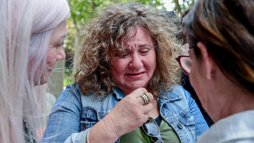 A woman reacts after pelvic mesh class action judgement in Sydney.