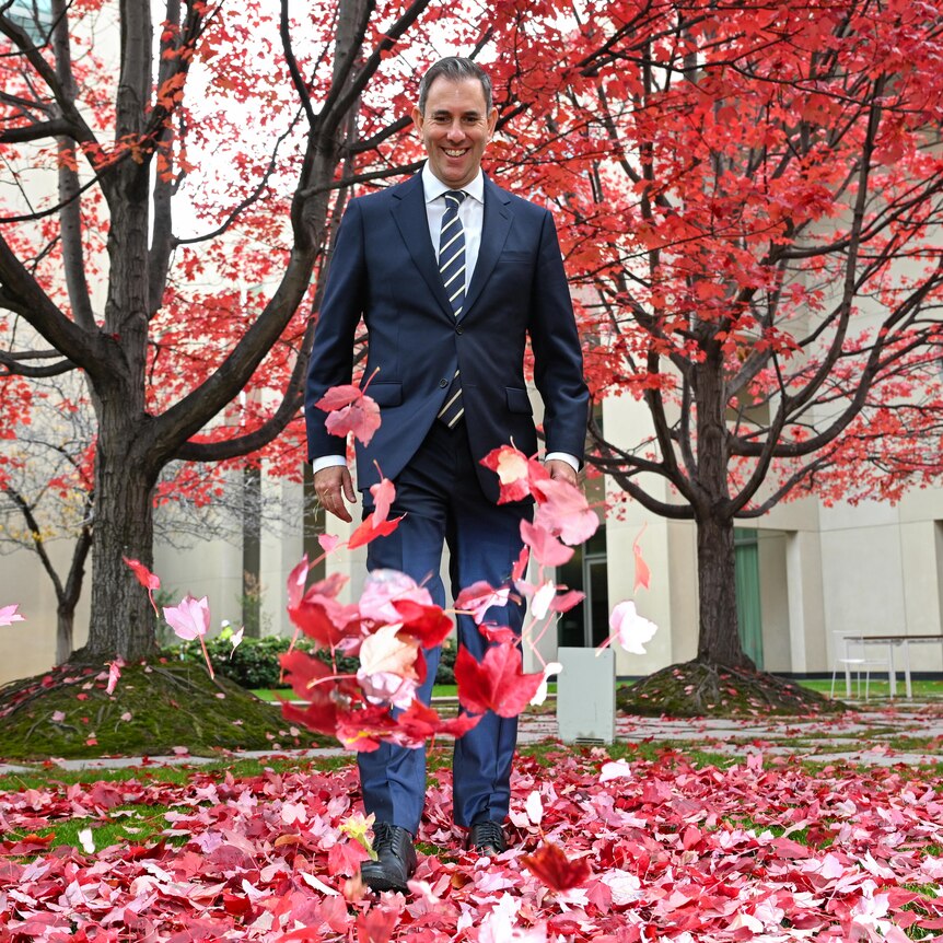 Jim Chalmers kicks red leaves in the courtyard at Parliament House.