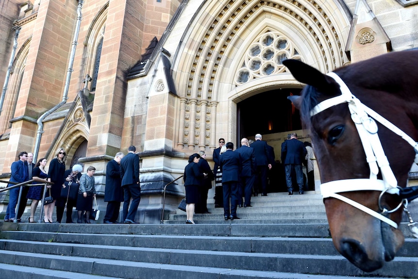 Mourners walk up the steps of St Mary's Cathedral in Sydney