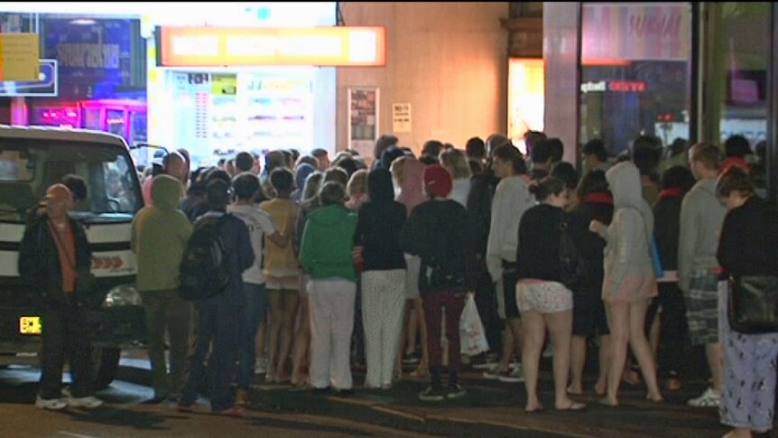 Backpackers on Sydney's Pitt street after a hostel fire