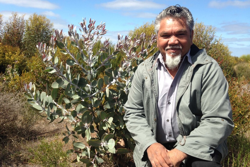 A photo of Eugene Eades in front of an area of revegetated land.