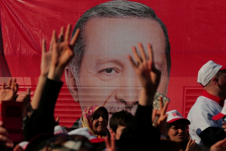 Supporters listen to a speech by Turkish President Tayyip Erdogan