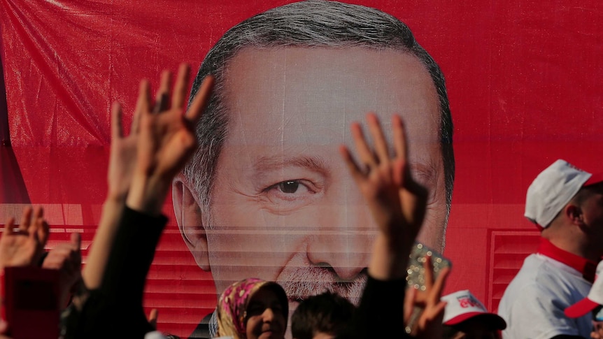 Supporters listen to a speech by Turkish President Tayyip Erdogan