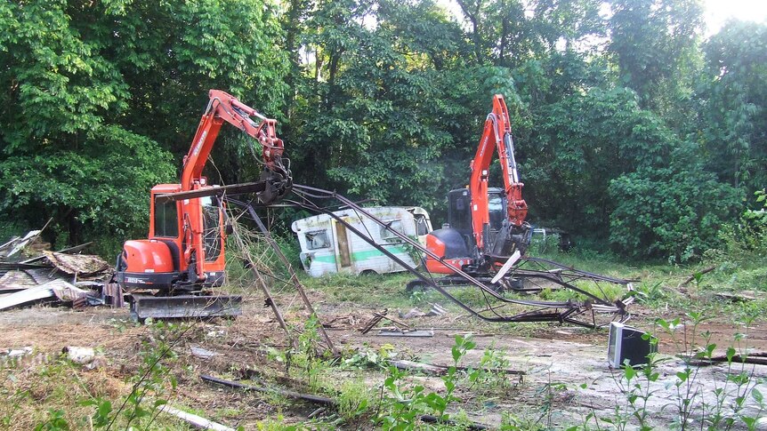 Two red excavators picking up rubbish on the property.