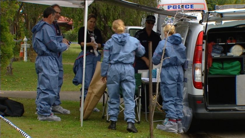 Forensic police officers outside the house where the twins were found dead.