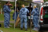 Forensic police officers outside the house where the twins were found dead.