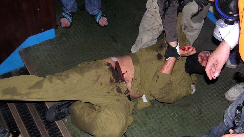 An Israeli soldier cowers as he is surrounded by activists on the Turkish aid ship, the Mavi Marmara