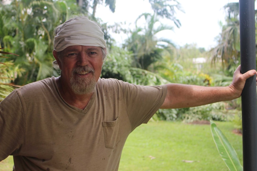 Kelvin James takes a break from clearing palm fronds from his Malak backyard.