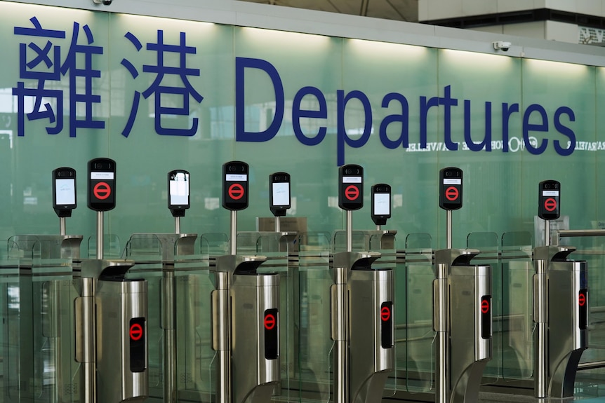 Closed airport counters with a "departures" in big writing on the wall behind.