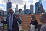Dean Nalder is confronted by traders at Barrack Square in Perth