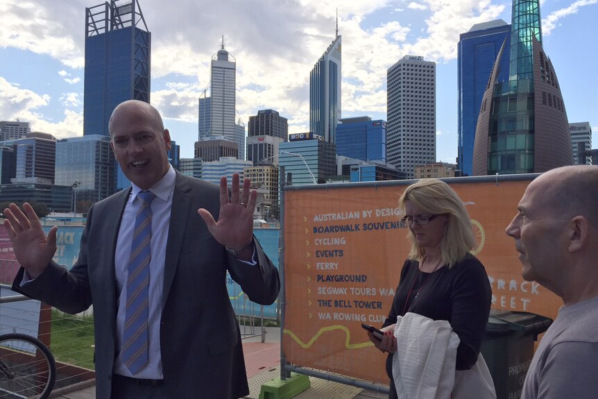 Dean Nalder is confronted by traders at Barrack Square in Perth