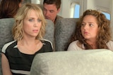 A still from the plane scene in the film Bridesmaids, where Kristen Wiig's character is afraid to fly.