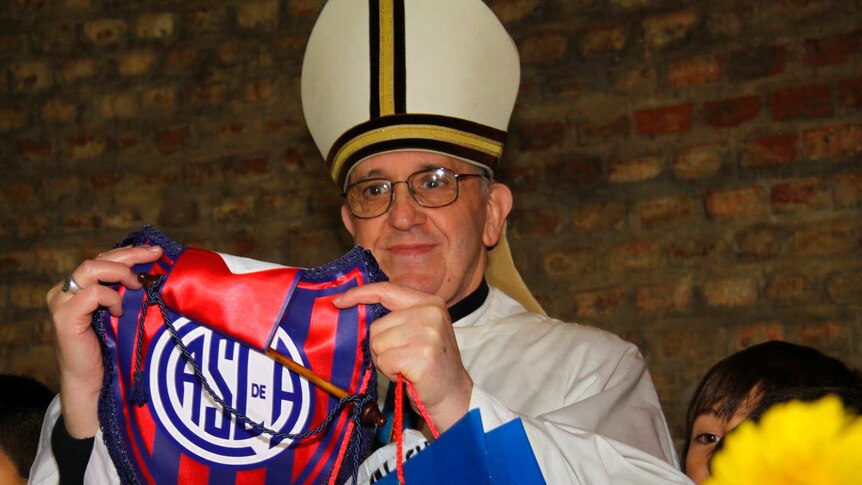 Cardinal Jorge Bergoglio poses with a pennant from the San Lorenzo football club, of which he is known to be a fan.
