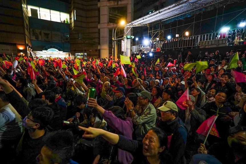 Ms Tsai's supporters wave flags outside in celebration.