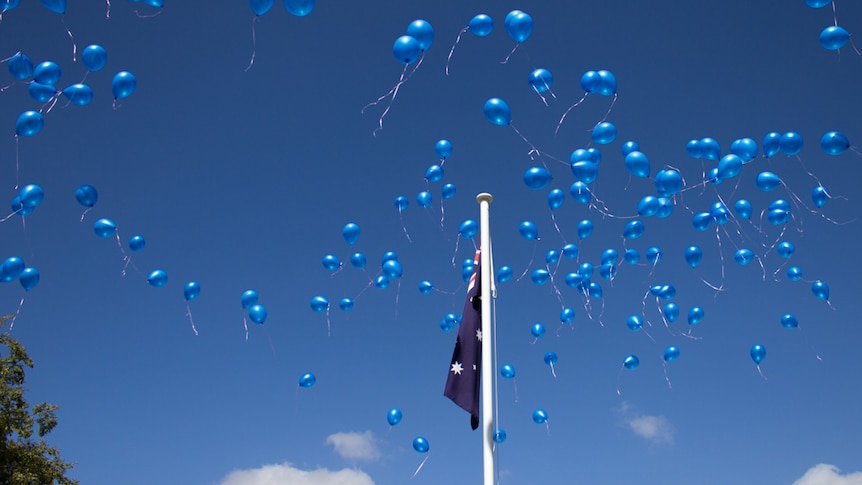 Blue balloons against a blue sky with the Australian flag.