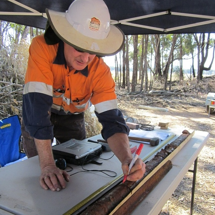 A staff member from GeosMining working on samples on a site overseas.