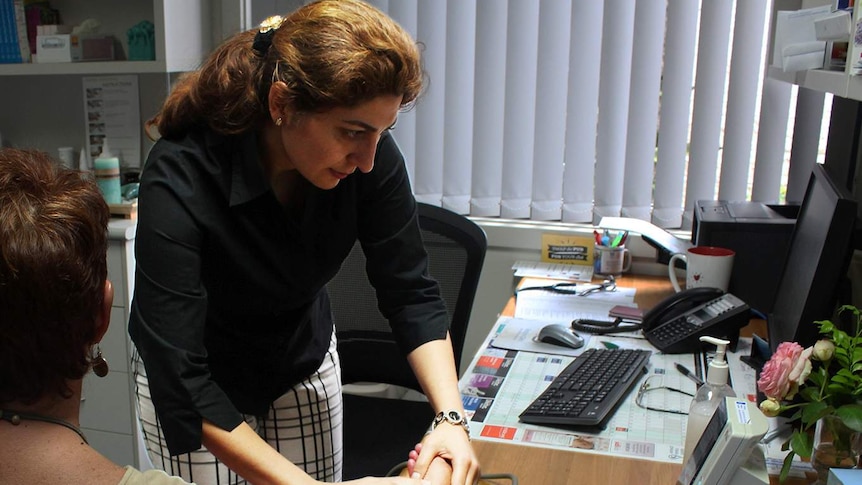 Dr Parisa Pour Ali takes a patient's blood pressure