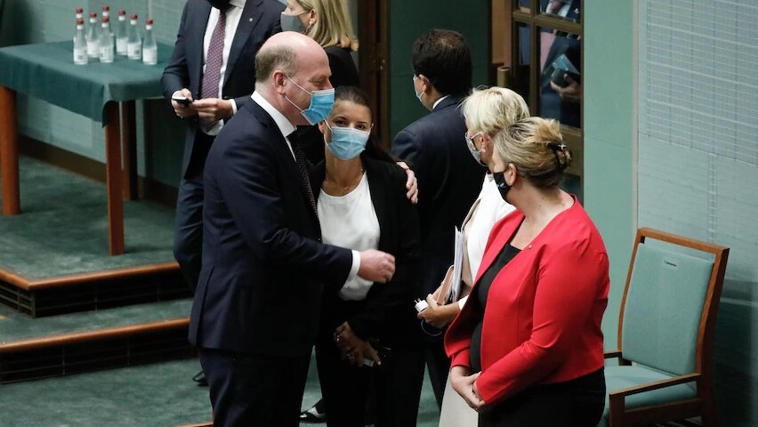 Trent Zimmerman wearing a mask and embracing colleagues.
