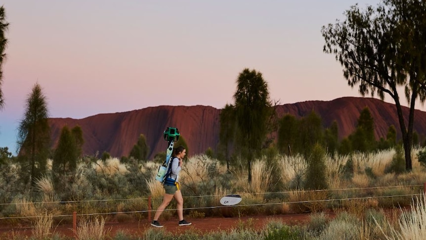 A girl treks with Google street-view camera.