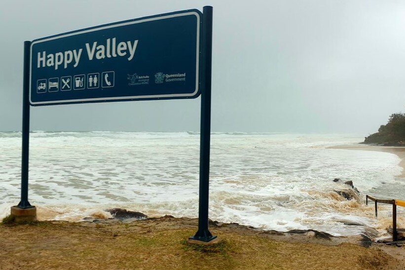 A sign for Happy Valley with the tide lapping at the bottom of it