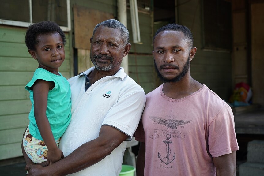 Saulo Honorobo (centre) is pictured with his daughter Jesinta Saulo (left) and David Saulo (right).