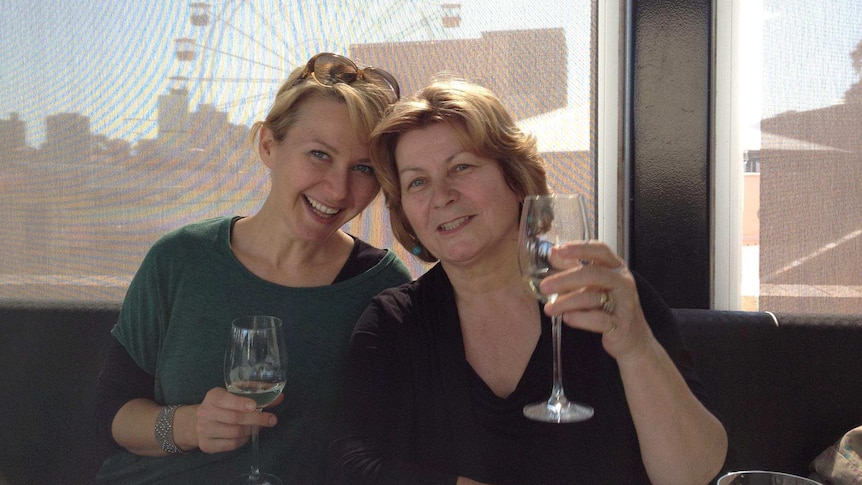 Mariana and her mother toast their champagne glasses at a restaurant