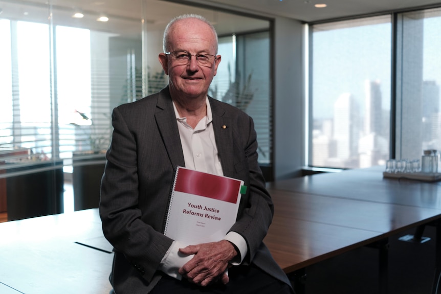 Profile of Youth Justice special adviser Bob Atkinson holding document saying Youth Justice Reforms Review document