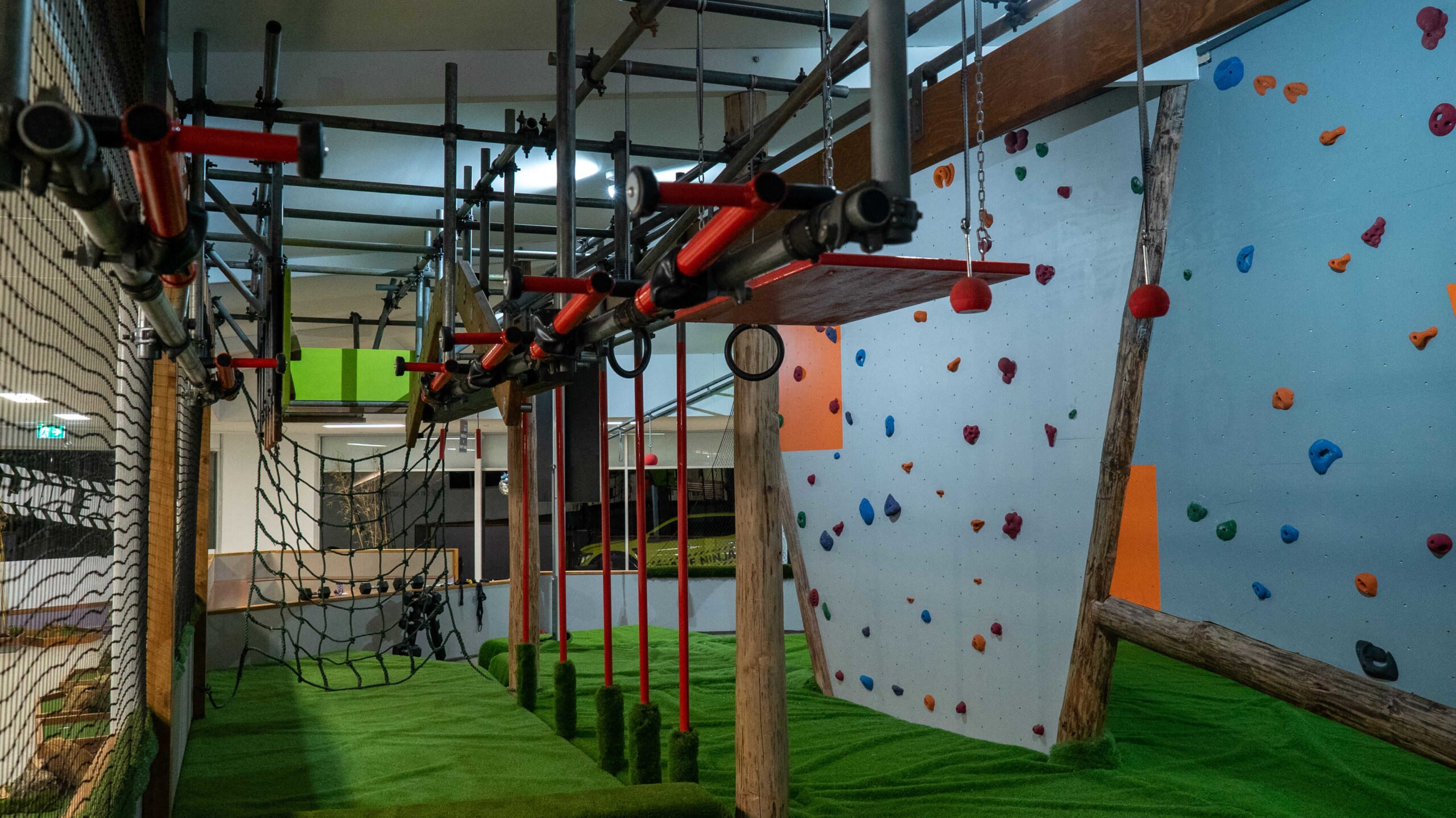 Obstacle equipment attached to the ceiling with rock climbing walls in the background. 