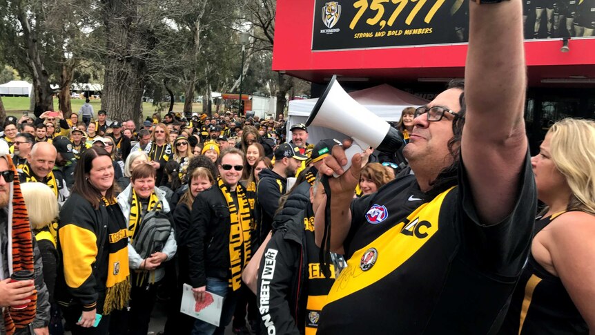 Richmond supporter John Games with a loud hailer outside Punt Road Oval.