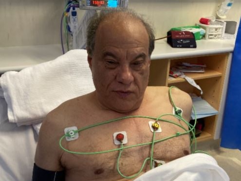 An elderly man lying in bed in hospital