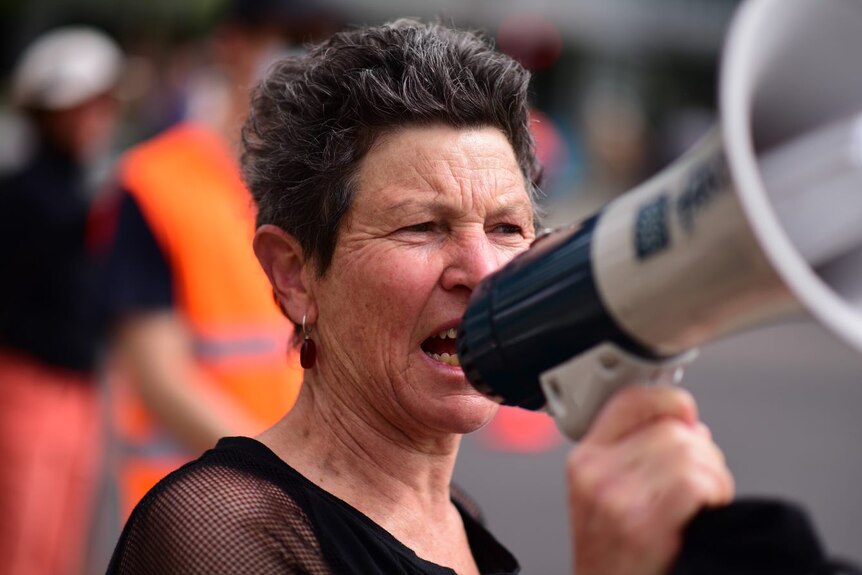 An Extinction Rebellion protester holds a megaphone.