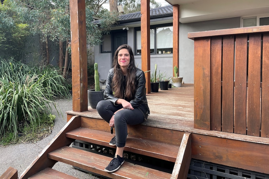 Ana Kresina smiles while sitting on the steps of a house, for a story abou the First Home Super Saver scheme.