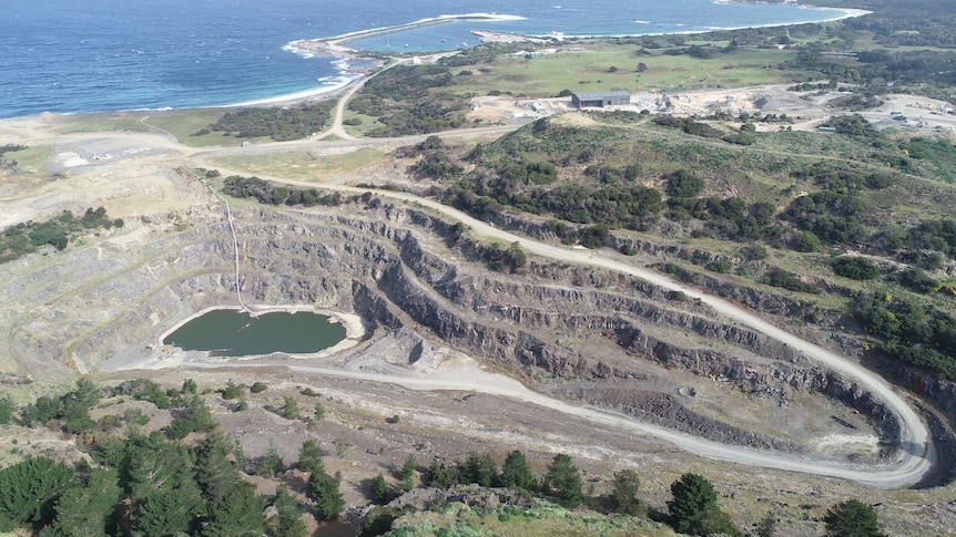 A birdseye view of an open-cut mine on the coastline