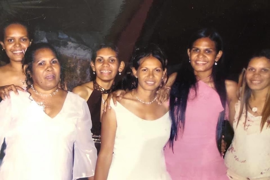 A photo of six sisters in formal dresses.